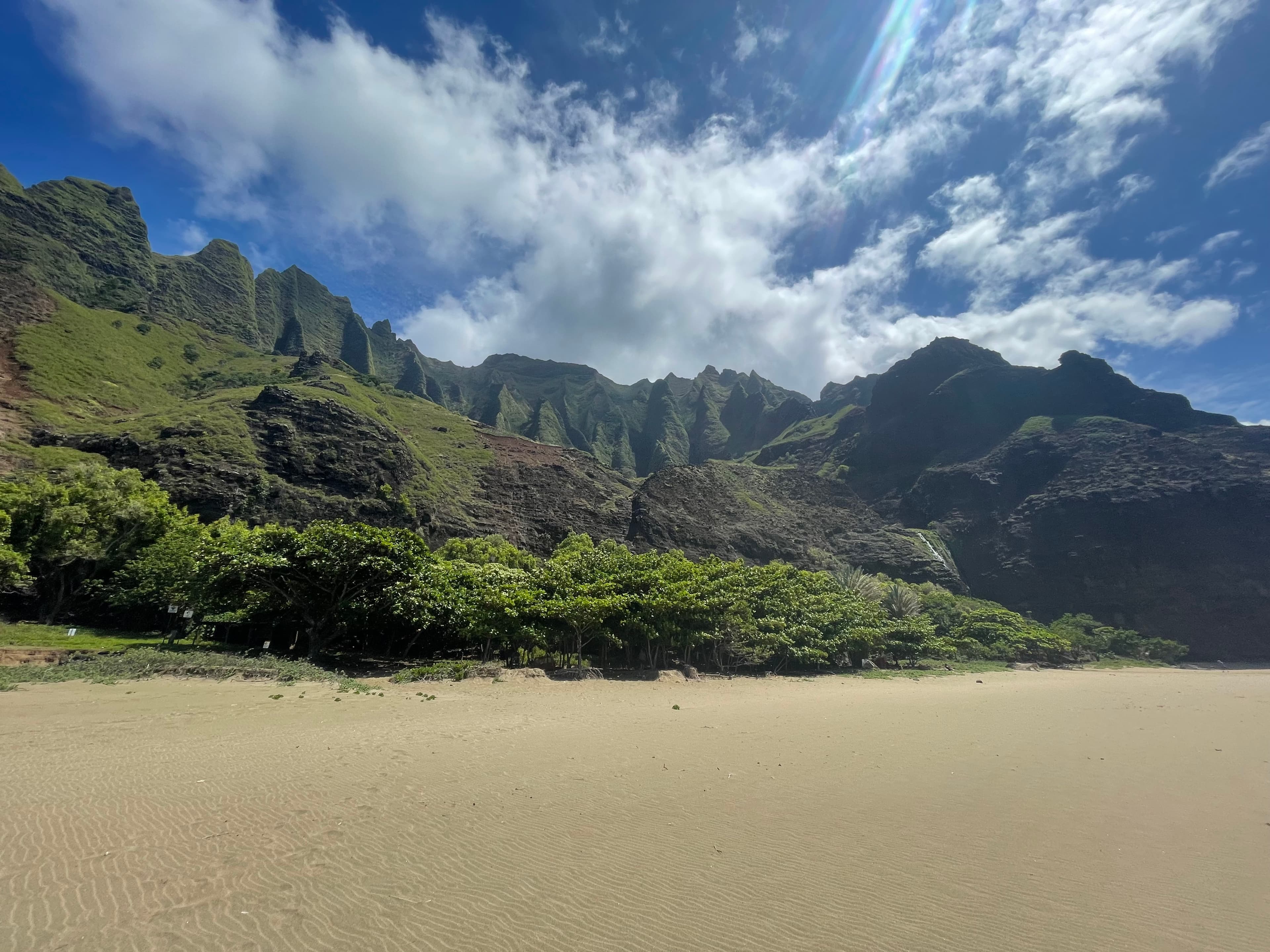 Kauaʻi beach shoreline with green coastal cliffs